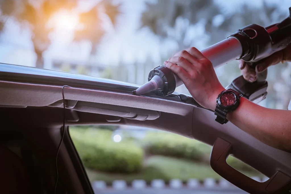 windshield repair shop Gwynn Oak - applying car glass sealant to the top of a windshield