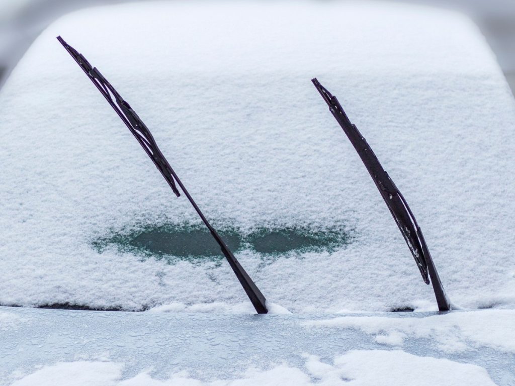 frozen car windshield covered in ice and snow, needing car windshield repair in Rognel Heights