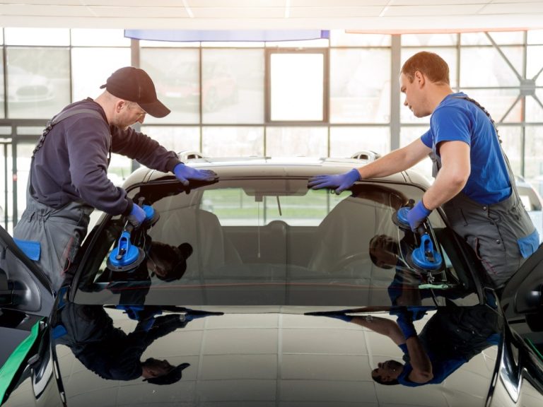 A team of professionals installing a new windshield, showcasing reliable Mobile Windshield Replacement in Baltimore