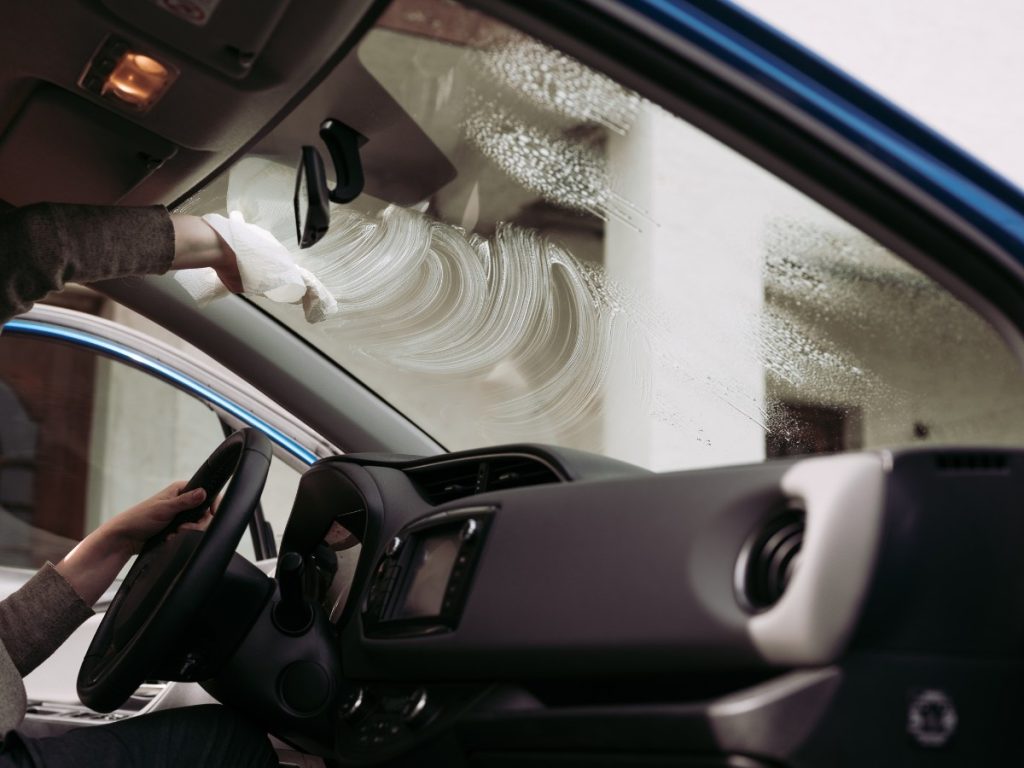 windshield glass replacement Gwynns falls/Leakin Park cleaning a car's interior glass with a white cloth