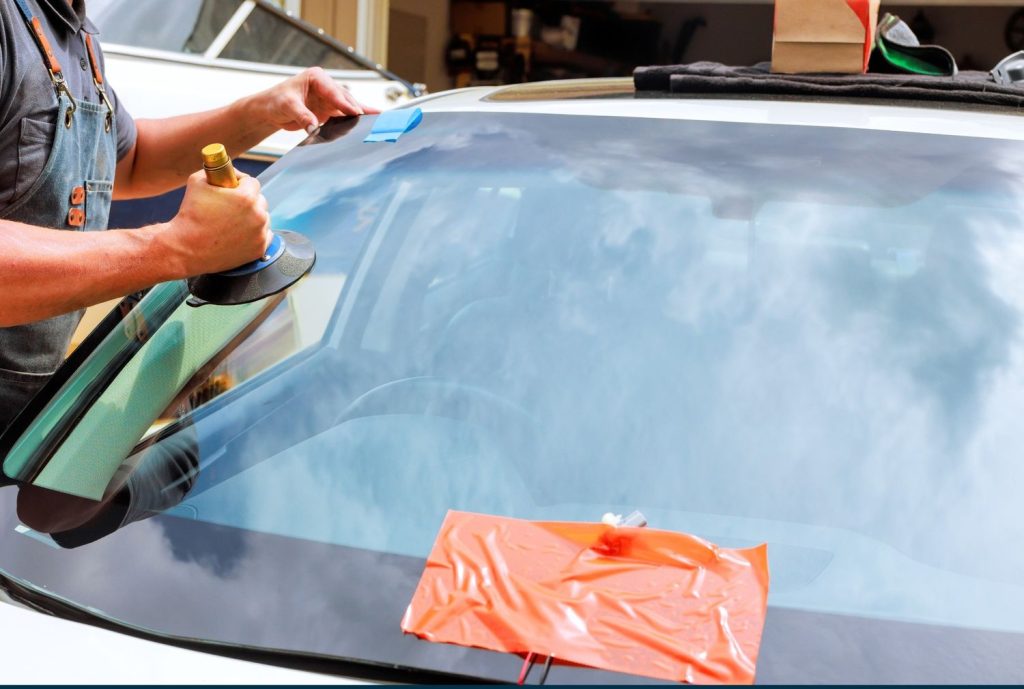 Specialist using a repair tool on the glass for a quality car windshield fix Baltimore replacement service.
