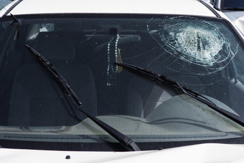 Shattered white car windshield from an impact needing emergency auto glass replacement Baltimore experts to install.