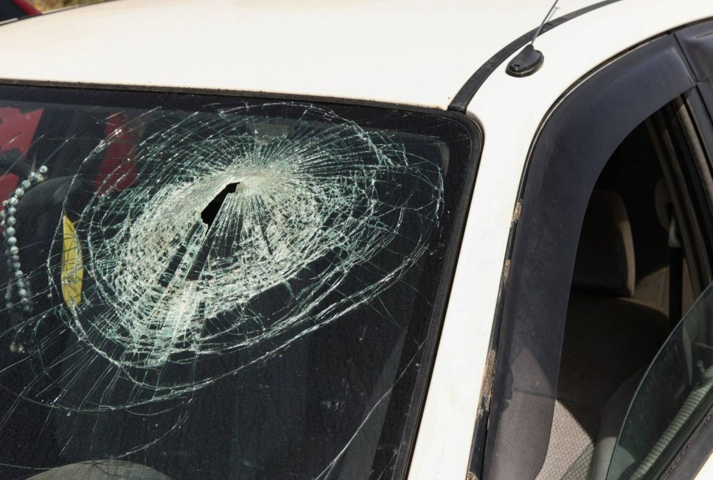 Close-up of severely damaged white car windshield needing replacement from the top auto glass specialists in Baltimore.