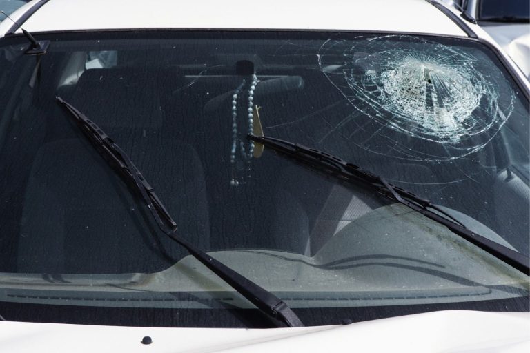 High impact shatter on a white car windshield, proof you need prompt service from auto glass specialists in Baltimore.