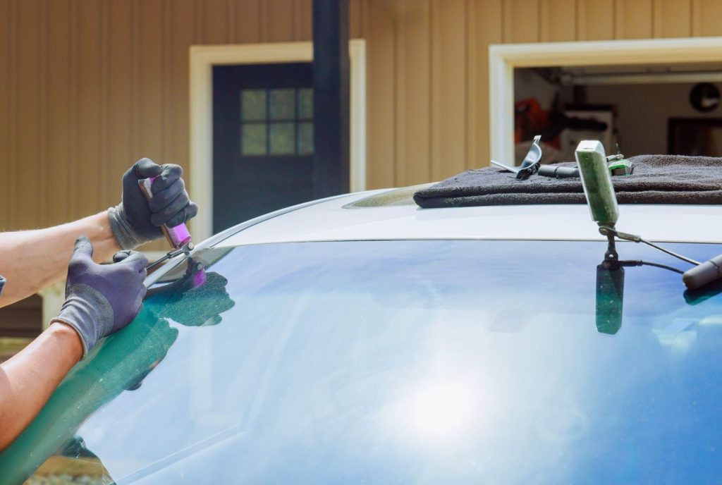 Completed installation of a new windshield by skilled hands, showing quality mobile windshield repair Baltimore results.