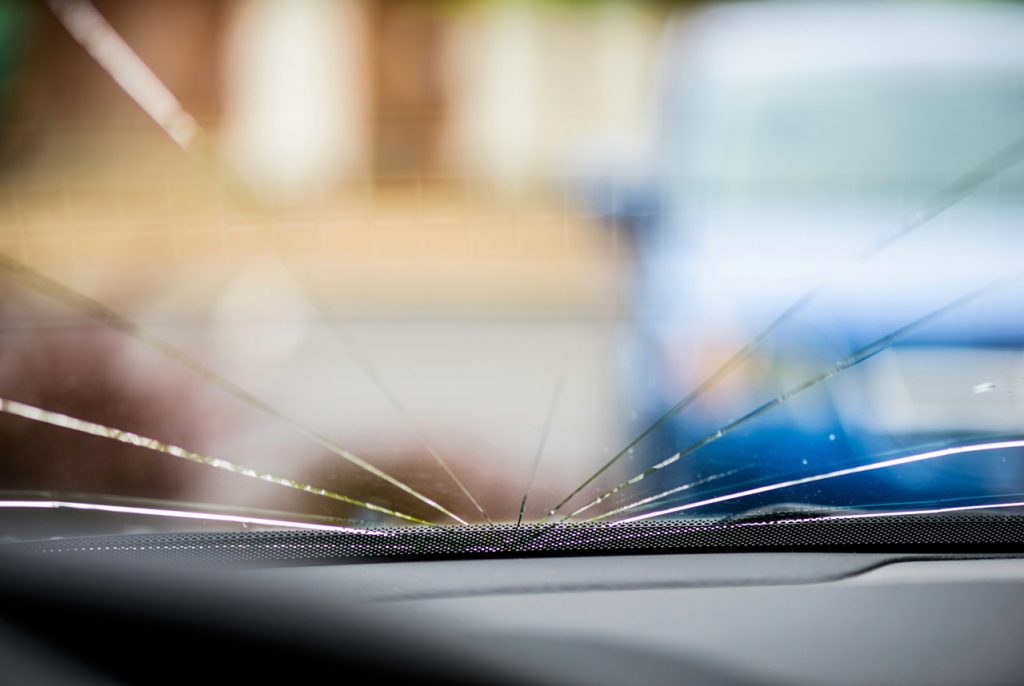 Professional windshield repair service Baltimore, fixing a large glass crack from inside the vehicle.