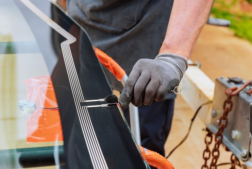 Professional technician applying primer for an auto glass fix Baltimore service to ensure a secure windshield bond.