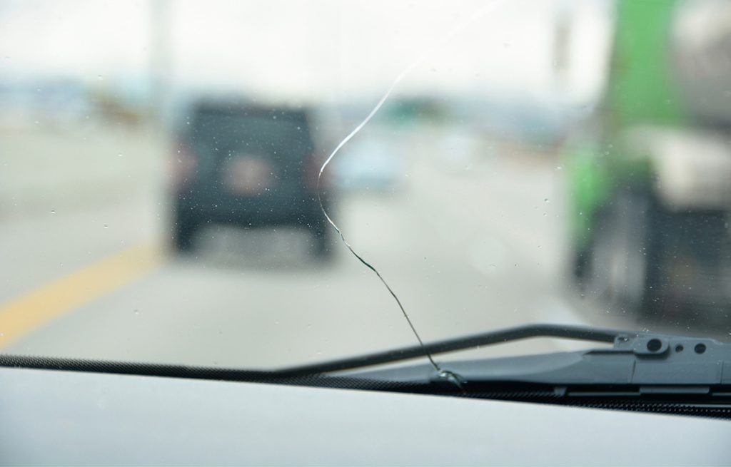 A long vertical crack in a windshield obscuring the driver's view; contact auto glass fix Baltimore for mobile repair.