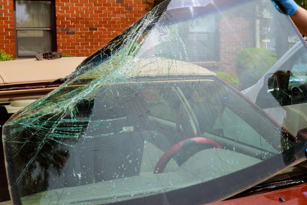 Expert mobile auto glass repair Baltimore technician removing a shattered windshield from a vehicle for replacement.