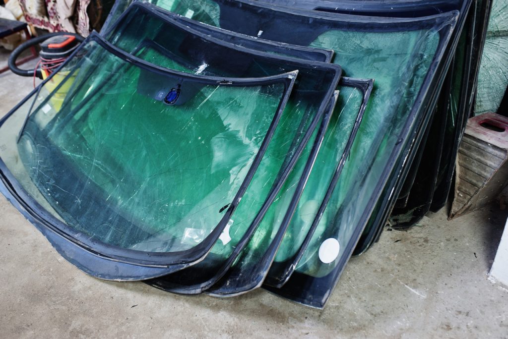 A large stack of high-quality glass inventory ready for expert windshield repair Baltimore at a local auto shop.