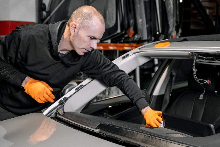 Expert technician preparing a vehicle frame for a windshield replacement at a professional auto glass shop Baltimore.
