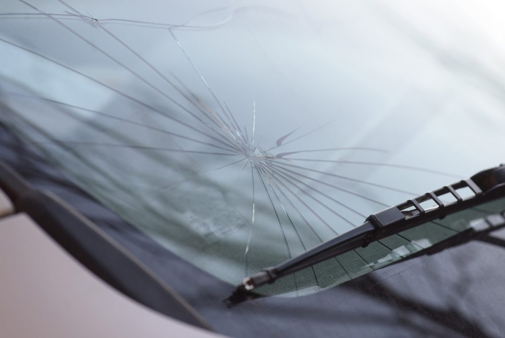 Large spiderweb crack on a car windshield requiring full replacement from an expert auto glass company Baltimore.