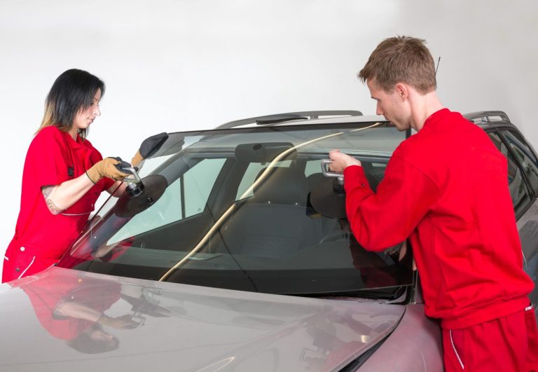 Expert team installing a new windshield using suction tools for a precise auto glass fix baltimore replacement.