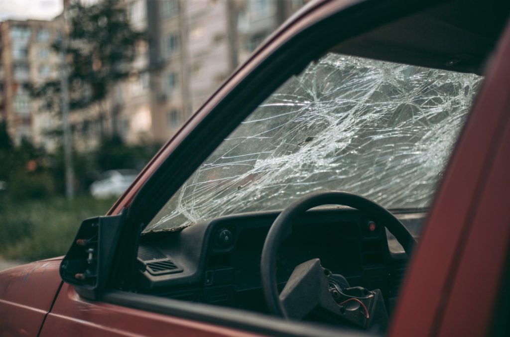 Shattered glass on a red car needing mobile windshield repair Baltimore services to restore vehicle safety.