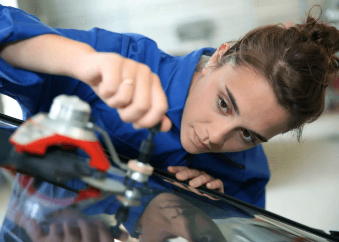 Expert technician performing a passenger windows repair Baltimore chip fix using a precision resin injection tool.