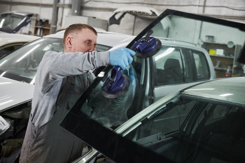 A skilled mechanic uses double suction cups to perfectly seat a new auto glass panel. Trust our shop for precision Back window replacement baltimore work.