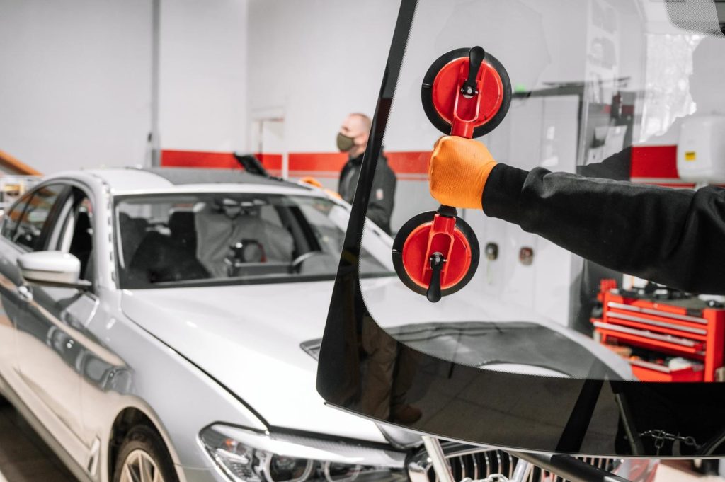 A new glass installation using suction cups at a professional automotive windshield repair shop Baltimore.