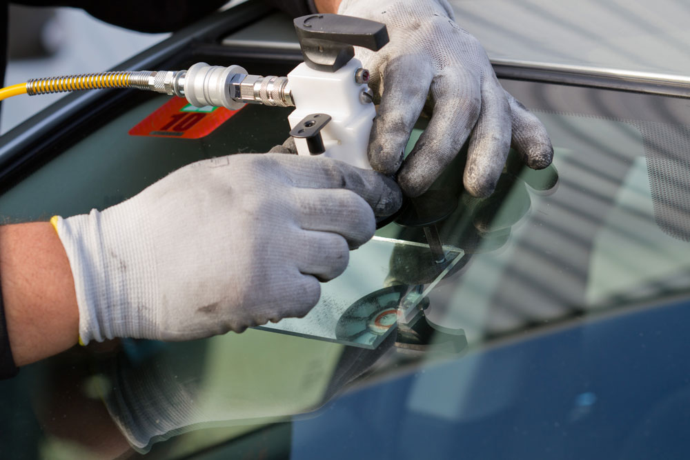 Close up of a technician fixing a cracked windshield for an expert mobile auto glass repair Baltimore service.