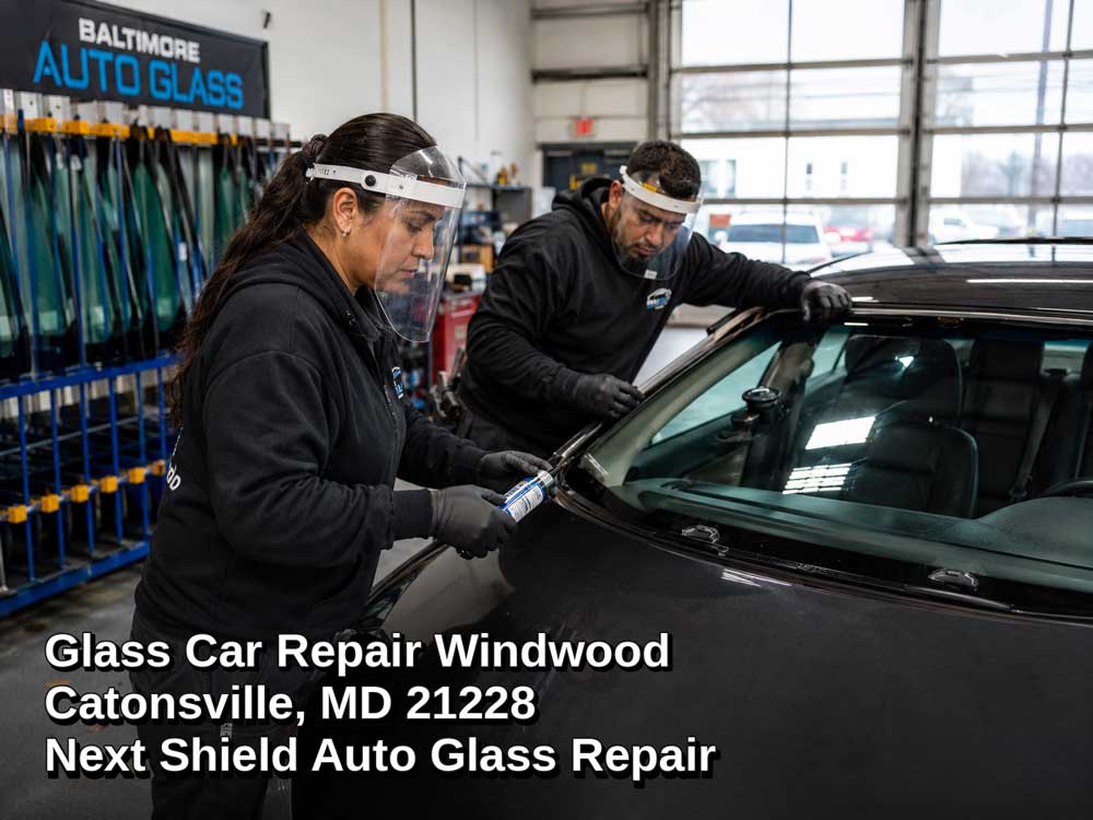 Professional auto technicians installing windshield adhesive for glass car repair in Baltimore MD shop setting.
